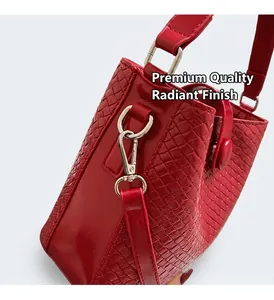 Détail du sac seau rouge à relief crocodile avec crochets et anneaux en métal argenté