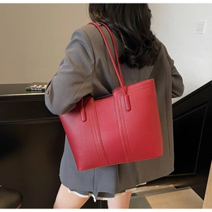 Mannequin portant un grand sac cabas rouge en cuir grainé au design minimaliste et chic