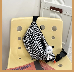 Détail du sac bandoulière pied-de-poule avec broderie STAY et charmant porte-clés peluche