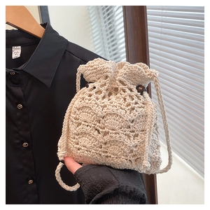 Détail du sac seau beige tissé main avec cordon de serrage et perles en bois marron foncé