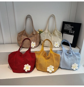 Detailed knit tote bags with daisy embroidery in five vibrant colors on white steps