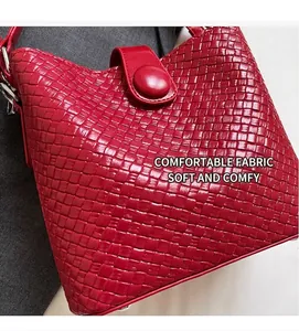 Gros plan détaillé du sac seau rouge tressé montrant sa texture et son fermoir magnétique