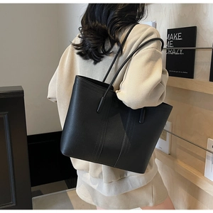 Gros plan du sac cabas en cuir grainé noir avec de longues bandoulières pour le quotidien
