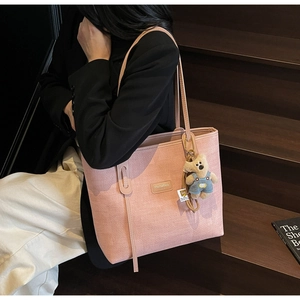 Pink woven tote bag featuring a cute teddy bear pendant and premium textured finish