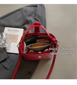 Vue détaillée de l'intérieur du sac seau tressé rouge montrant sa grande capacité de rangement