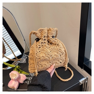 Détail du sac seau évidé tissé à la main avec cordon de serrage et perles en bois