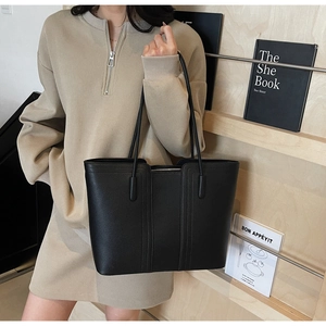 Détail du sac cabas en cuir grainé noir avec coutures verticales et fermeture éclair