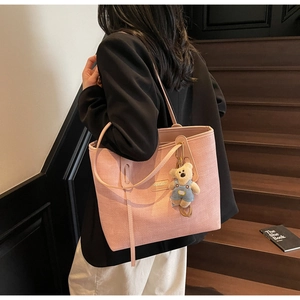 Detail of pink woven tote bag with Mashakeke logo and cute bear charm on shoulder
