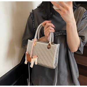 Détail du mini sac cabas tressé argenté avec breloque cheval et longue bandoulière