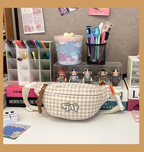 Détail d'un sac banane rétro à motif pied-de-poule avec écusson STAY brodé