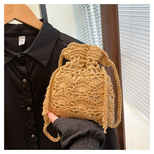 Gros plan d'un sac seau tressé à cordon avec motif ajouré dans une teinte naturelle