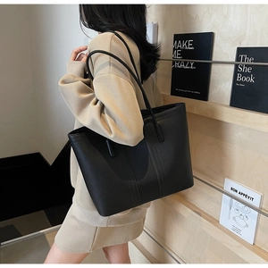 Gros plan du sac cabas en cuir noir grainé avec des détails de coutures verticales