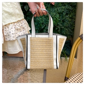 Close-up of beach straw tote bag featuring white faux leather contrast and weave texture