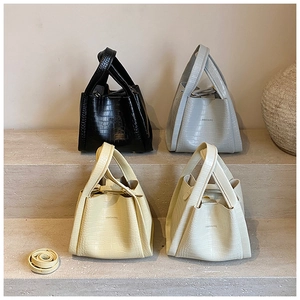 Detail view of four crocodile pattern bucket bags with detachable shoulder straps