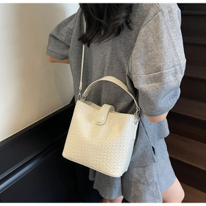 Détail de la texture en cuir tressé et du fermoir magnétique du sac seau blanc