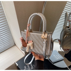 Détail du petit sac tressé argenté avec breloque cheval et bandoulière amovible