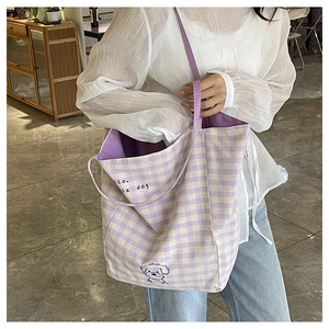 Détail du sac cabas en toile avec motif à carreaux violets et chiot brodé mignon