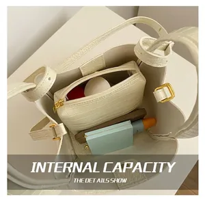 Detail view of cream bucket bag with crocodile texture showing interior capacity and inner pouch