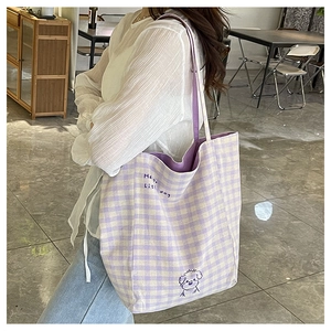 Détail d'un sac cabas à carreaux violets et blancs avec une illustration de chien
