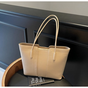 Détail du grand sac cabas en cuir grainé beige avec surpiqûres et fermeture éclair