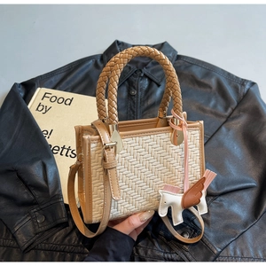 Vue détaillée du sac à main tissé beige avec bordure en cuir marron et breloque cheval