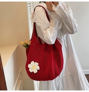 Detail of red woven tote bag with white daisy flower and thick woven strap