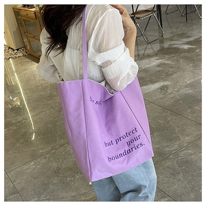 Gros plan d'un grand sac cabas en toile violette avec un slogan imprimé épuré