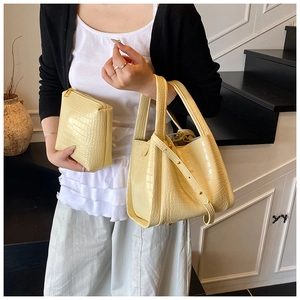 Detail of beige crocodile pattern tote with matching pouch and detachable strap