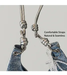 Detail of blue denim tote bag with silver knotted strap and pearl lace embellishments