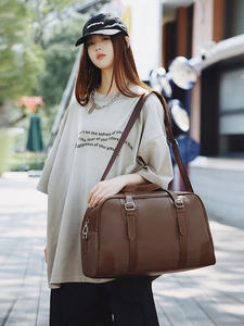 Deep brown leather travel Boston bag with adjustable shoulder strap for women