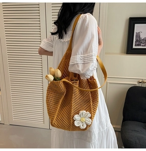 Close-up of ginger hand-woven tote bag with white crochet flower and leather strap