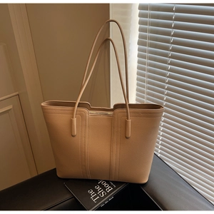 Détail du sac cabas beige en cuir grainé avec fermeture éclair et texture raffinée