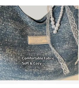 Detail of blue denim tote bag featuring sparkling rhinestones and metal fashion label