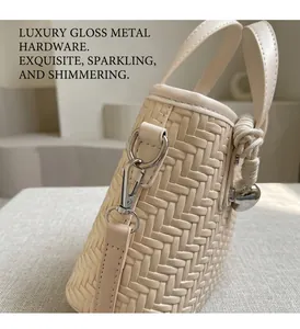 Dettaglio borsa a secchiello beige intrecciata con fibbia argento e manico a corda