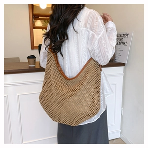 Détail du sac à bandoulière en paille tissé main avec bordure en cuir marron au café