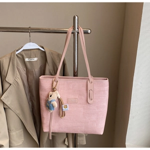 Pink woven tote bag featuring a cute teddy bear charm and matching long shoulder strap