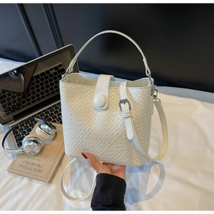 Vue détaillée du sac seau blanc avec texture crocodile et boucle métallique argentée