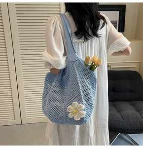 Detail of light blue crochet beach tote with 3D white daisy flower and leather strap