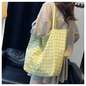 Gros plan d'un sac cabas en toile à damier vert avec motif de chien de dessin animé