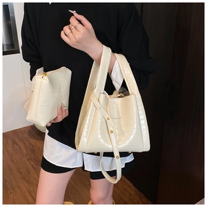 Detail of cream crocodile embossed tote bag set with matching zippered clutch purse