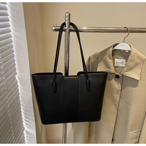 Détails du sac cabas en cuir noir à grain litchi avec coutures et sangles d'épaule