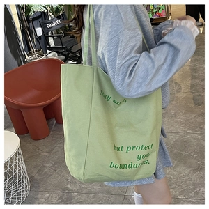Mannequin portant un sac fourre-tout en toile vert avocat avec slogan Stay Soft
