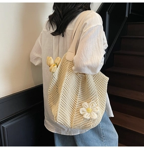 Detail of cream woven tote bag featuring 3D daisy flower and textured crochet finish