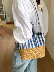 Blue striped canvas and straw woven tote bag with adjustable shoulder strap and handles