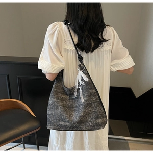 Détail du sac bandoulière vintage en tweed gris avec breloque en dentelle et perles