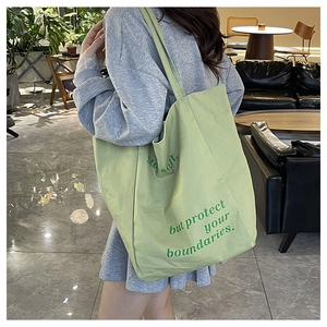 Détail du sac cabas en toile vert clair avec le texte Stay soft, but protect your boundaries