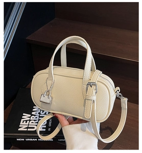 Close-up of beige lychee grain mini Boston bag with dual handles and detachable strap