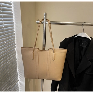 Détail d'un cabas beige minimaliste en cuir grainé avec des coutures verticales