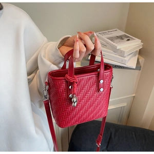 Primo piano della borsa a secchiello intrecciata rossa con dettagli in metallo argento