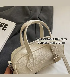 Detail of white lychee texture Boston bag with silver zipper and padlock charm